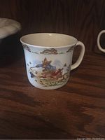 Porcelain coffee mug with colorful Bunnykins rabbit scene showing rabbits playing and running.