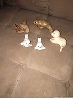 Photo showing all five seal and sea lion figurines arranged on a beige couch