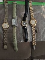 Photo showing all four vintage wristwatches side by side on plastic packaging.
