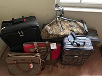 Photo showing all five pieces of luggage and the garment bag arranged on the floor near a window.
