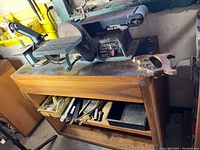 Delta sander unit showing four-inch sanding belt and six-inch sanding disc mounted on a wooden workbench in a workshop environment.