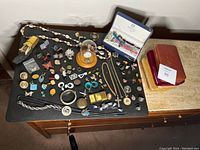 Mixed lot laid out on tabletop showing watches, jewelry and boxes