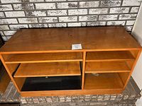 Front view of the solid wood entertainment center showing open shelving and a pull-out tray.