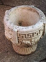 Front view showing the wide rim and upper decorative ribbon detail on the concrete urn.