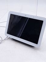 View of front-facing touchscreen with white bezel showing Google Nest Hub device powered by cable.