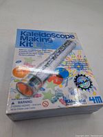 Image of original box showing 'Kaleidoscope Making Kit' label and product image with colorful stars and shapes illustration.