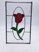 Full view of the stained glass panel showing the rose design and metal frame.