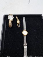 Three women's watches displayed in a box, showing all included watches and their bands.