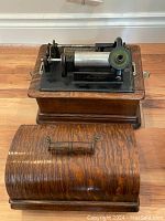 Phonograph mechanism on oak base with hinged wood cover removed