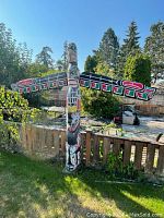 Front view of totem pole in backyard showing overall appearance and scale