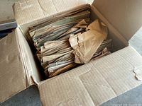 Box packed with numerous vintage LP vinyl records in original paper sleeves, some visibly worn and creased.