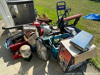 Wide view of lot showing pressure washer, toolbox, bins, and various items piled on ground