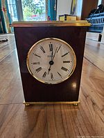 Front view of the small Birks mantel clock showing the clock face with Roman numerals and brass trim.