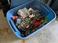 Blue storage tote filled with assorted vintage and used hand tools and hardware.