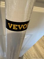 Close-up image of the rolled VEVOR dry erase sticker featuring the black band with yellow VEVOR logo, showing original packaging.