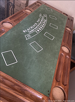 Blackjack poker table top on wooden bar with integrated cup holders and slots, showing green felt with printed Blackjack layout