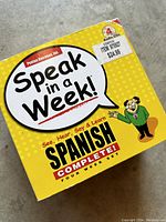Front view of the yellow boxed set titled 'Speak in a Week! Spanish Complete' showing it's a four-week set with 4 audio CDs by Penton Overseas Inc.