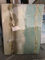 Full view of the first abstract print framed with earthy and greenish-blue tones with gold accents.