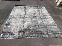Full view of the rug laid flat on pavement showing overall size and pattern