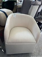 Front view showing curved back and armrests and white upholstery