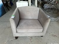 Front view of one armchair showing seat cushion, backrest, armrests and wooden legs.