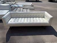 Front view of white tufted sofa showing seat and arms