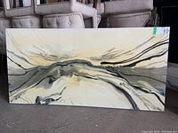 Full front view of the abstract textured canvas print on the floor near upholstered chairs, showing the overall design and size.