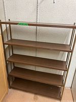 Full view of the metal frame book shelf showing five brown wood shelves and metal side frames.