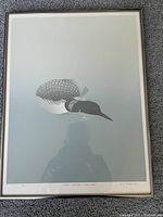Full view of the framed John Reuben print featuring a loon in water with a muted color palette.