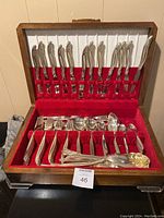 Full view of wooden case opened to show the silverplate cutlery set with knives in the lid and forks, spoons in base