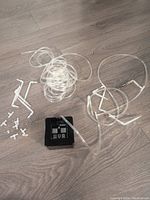 Full view of the Moistenland automatic drip irrigation system components arranged on floor, including control unit, multiple clear plastic tubing, and white plastic connectors.