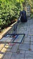 Overall view of portable hoop assembly with base, pole, and backboard on patio