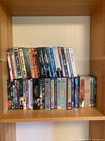 Shelf with a collection of various DVD titles including That 70's Show, Battlestar Galactica, Futurama, and assorted movies.