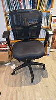 Front view of ergonomic office chair showing padded seat, mesh back, and armrests