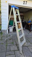 Full side view of the 6-foot aluminum step ladder, standing open on a patio.