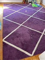 Wide view of the rectangular purple area rug with white diamond pattern, showing size and layout.