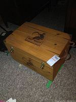 Closed top view of wooden crate cooler with Fort Garry Brewing Co. logo showing natural wood grain and brass latches.