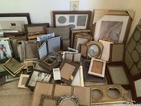 Overview of assorted picture frames stacked and leaning against wall