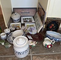 Overall view of all kitchen and decorative items including sign, plates, ceramic jars and dishes, salt and pepper, tiles, and pitcher.