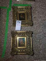 Two small framed oil paintings with floral still life subject matter, each approximately 2.5 x 3.5 inches, with ornate gold frames.
