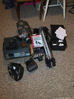 Overview of lot: cameras, tripods, developing tank, slide sorter, projector, lens box