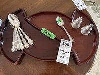Wood serving tray with spoons, teaspoon, and salt and pepper shakers placed on it
