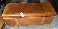 Front and top view of cedar chest showing wood veneer pattern and scratches