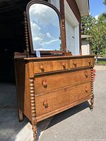Full view of antique spindle dresser with attached mirror, showing spindle legs and shaping, round wooden drawer pulls, and overall condition.