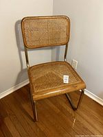 Front and side view of the Cesca style chair showing woven cane seat and backrest with brass frame