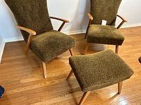 Two mid-century modern lounge chairs and matching ottoman upholstered in brown boucle fabric with wooden frames
