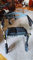 Front view of Evolution Xpresso Wide walker showing padded seat and two front wheels