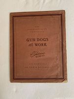 Portfolio cover titled 'Gun Dogs at Work' by Edwin Megargee, showing worn brown cover with title and illustration of a gun and dog items.