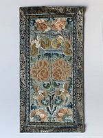 Full view of the embroidered Chinese silk robe panel showing floral embroidery with cream, peach, gold, and blue-green tones, framed by dark patterned border.