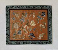 Full view of the embroidered silk textile panel with floral motifs, showing the bordered edges and overall condition.
